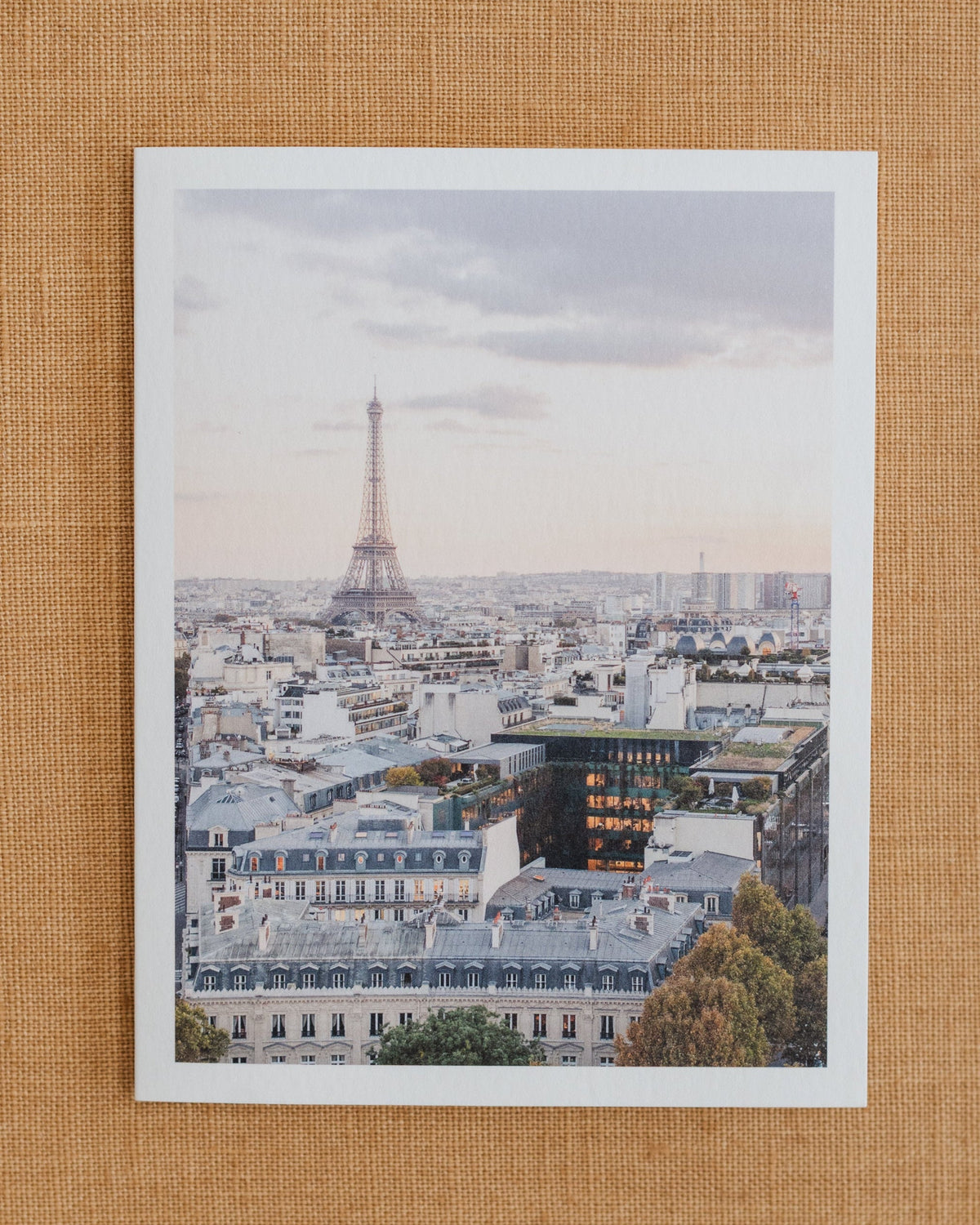 Photographic notecard showing the Eiffel Tower above Paris rooftops.