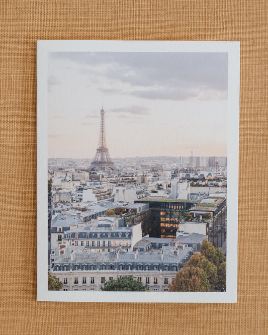 Photographic notecard showing the Eiffel Tower above Paris rooftops.