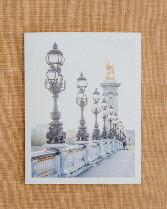 Photographic notecard showing the ornate lamps and balustrade of Pont Alexandre III in Paris.