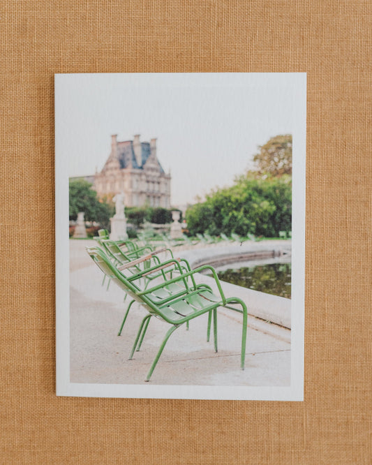 Photographic notecard featuring green garden chairs beside a fountain in Paris.